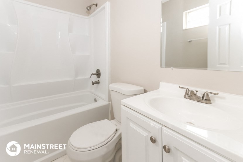 a white bathroom with a sink toilet and tub