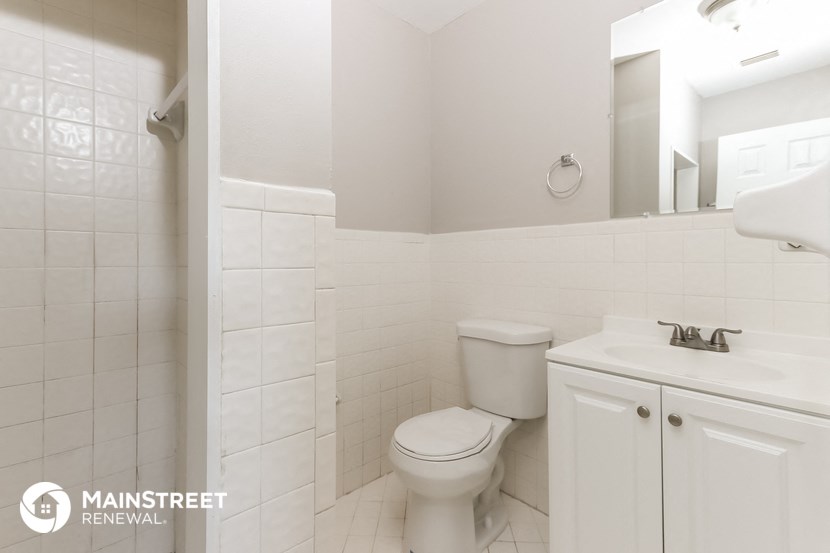 a white bathroom with a toilet and a sink