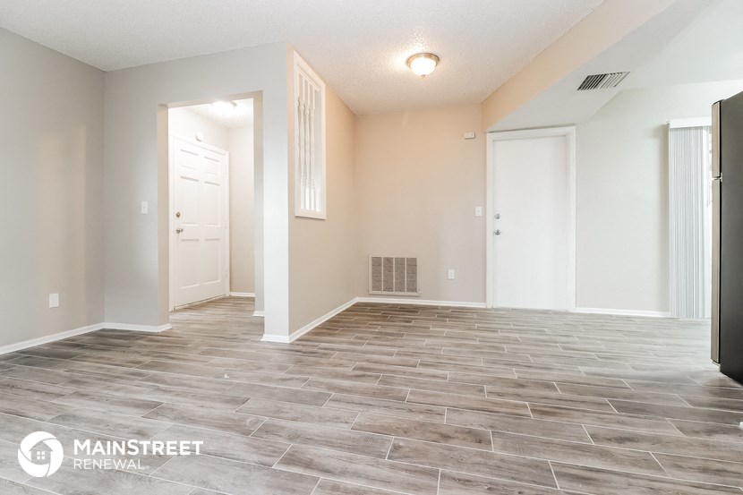 the spacious living room with tile flooring and white walls