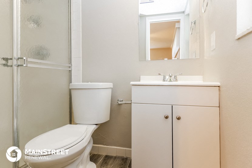 a bathroom with a toilet and a sink and a shower