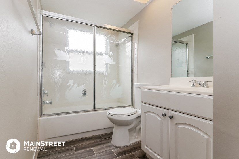 a bathroom with a shower and a toilet and a sink