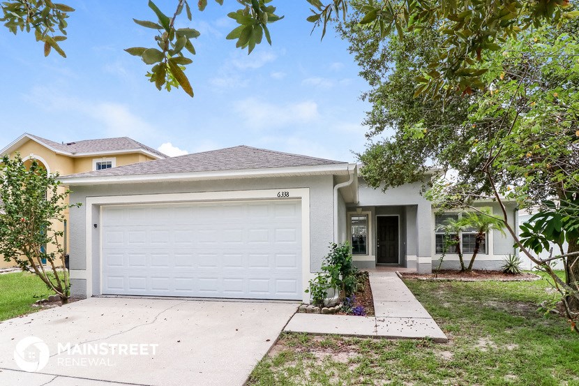 a white house with a white garage door and a driveway