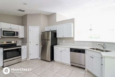 a white kitchen with stainless steel appliances and white cabinets
