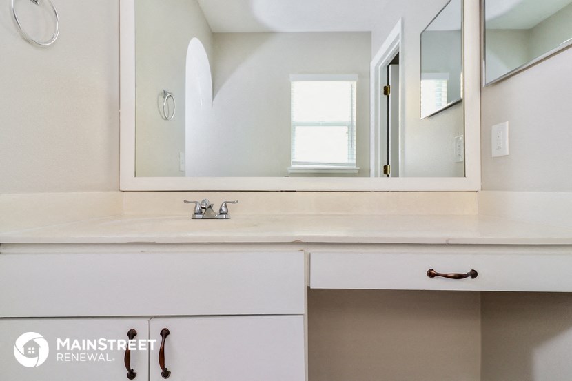 a bathroom with a vanity with a mirror and a sink