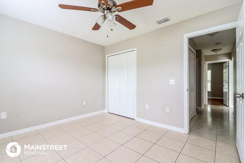 an empty living room with a ceiling fan