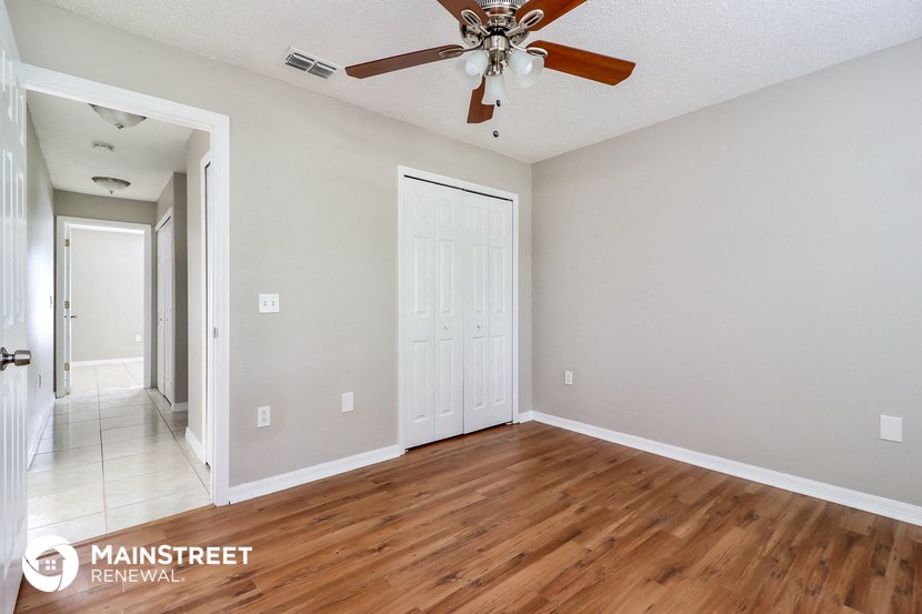 a living room with wood floors and a ceiling fan
