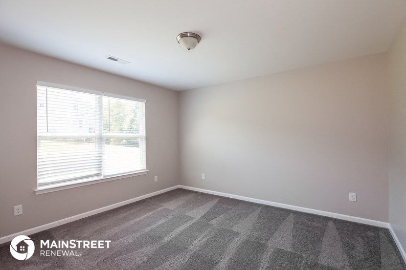 the spacious living room of a new home with a large window