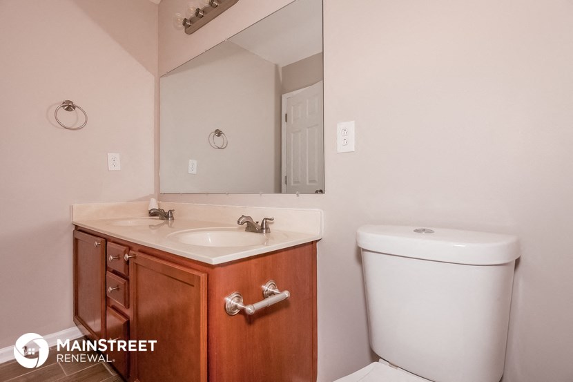 a bathroom with a toilet and a sink and a mirror