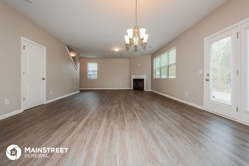 the spacious living room with wood floors and a fireplace