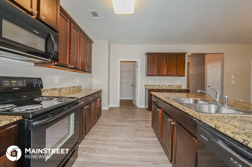 a kitchen with wooden cabinets and granite counter tops and black appliances