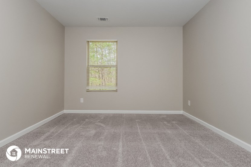 a empty room with carpet and a window