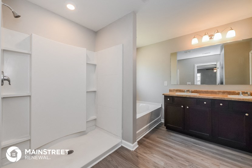 a bathroom with a tub and a sink and a mirror