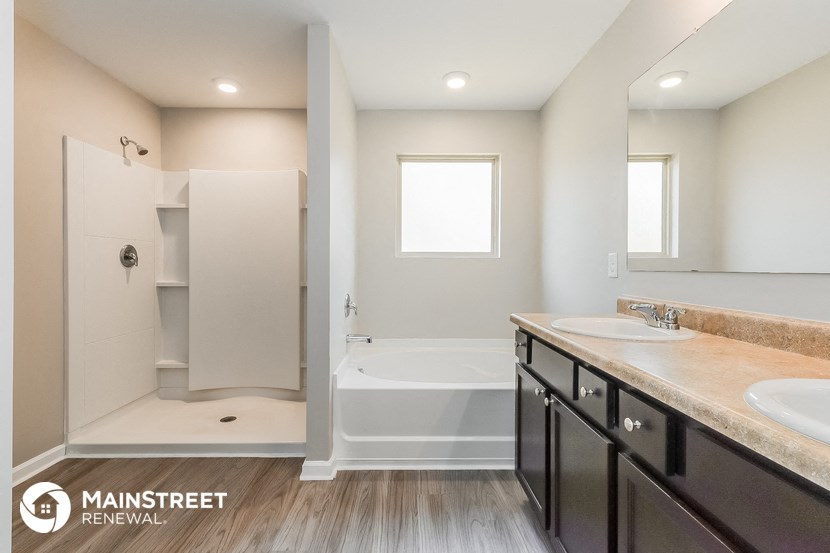 a bathroom with two sinks and a shower and a bath tub