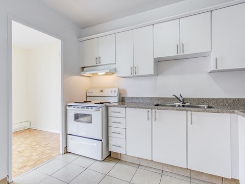 a kitchen with white cabinets and a sink and a stove