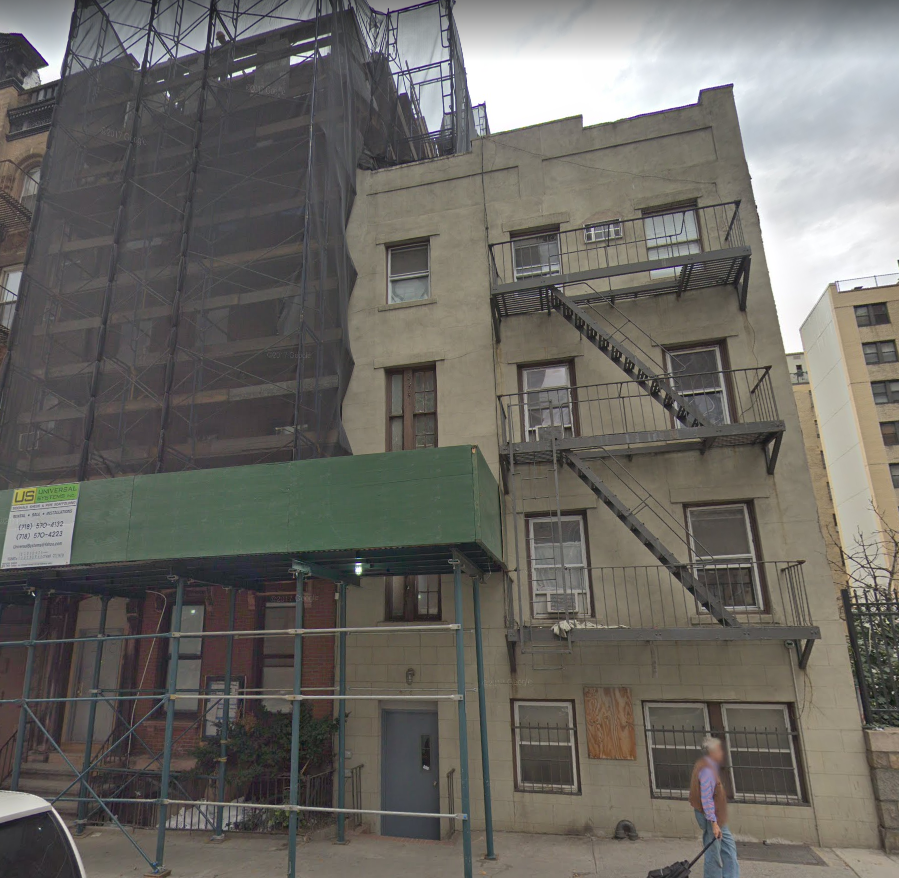 a building with scaffolding on it and a man walking