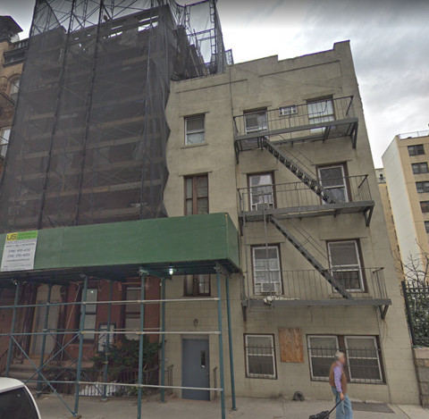 a building with scaffolding on it and a man walking