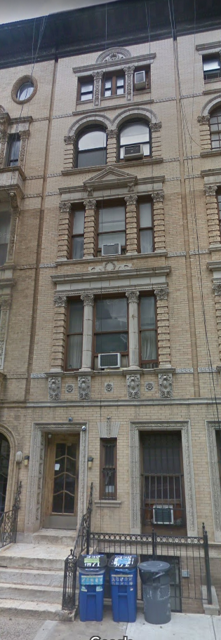 the front of a building with trash cans in front of it