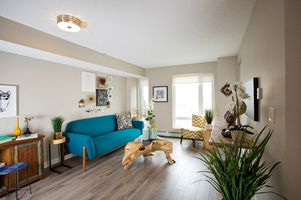 a living room with a blue couch and a wood floor