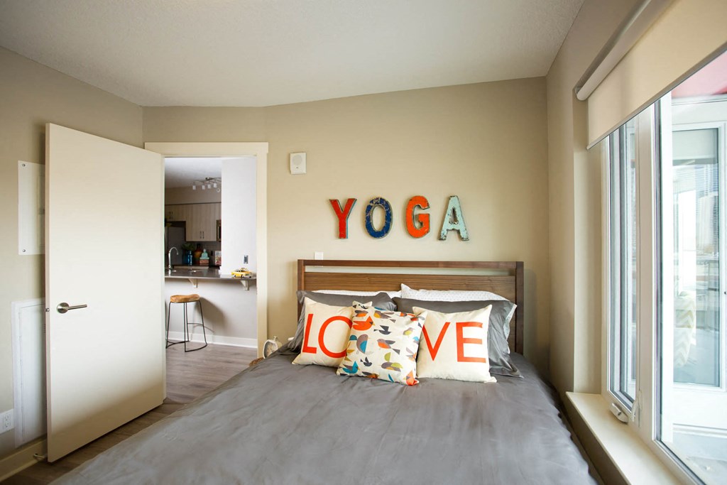 a bedroom with a bed and a yoga sign on the wall