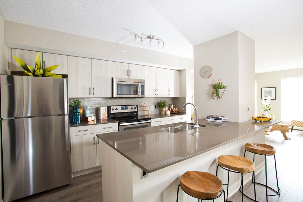 a kitchen with a counter top and a stainless steel refrigerator