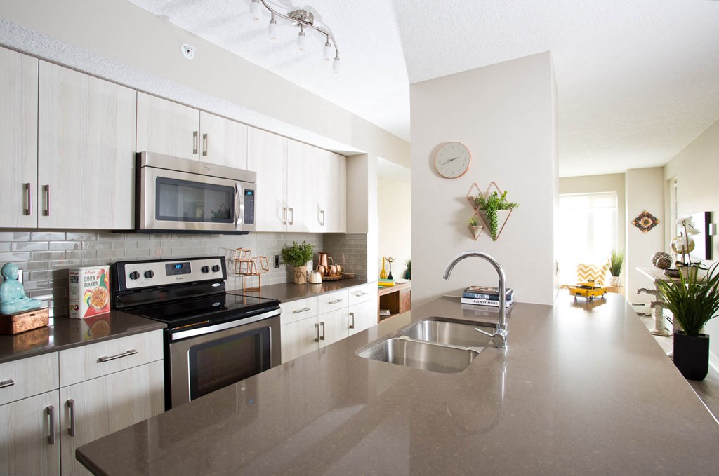 a large kitchen with stainless steel counter tops and white cabinets