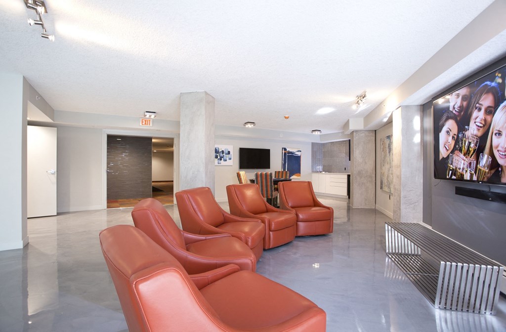 a living room with red leather chairs and a large tv