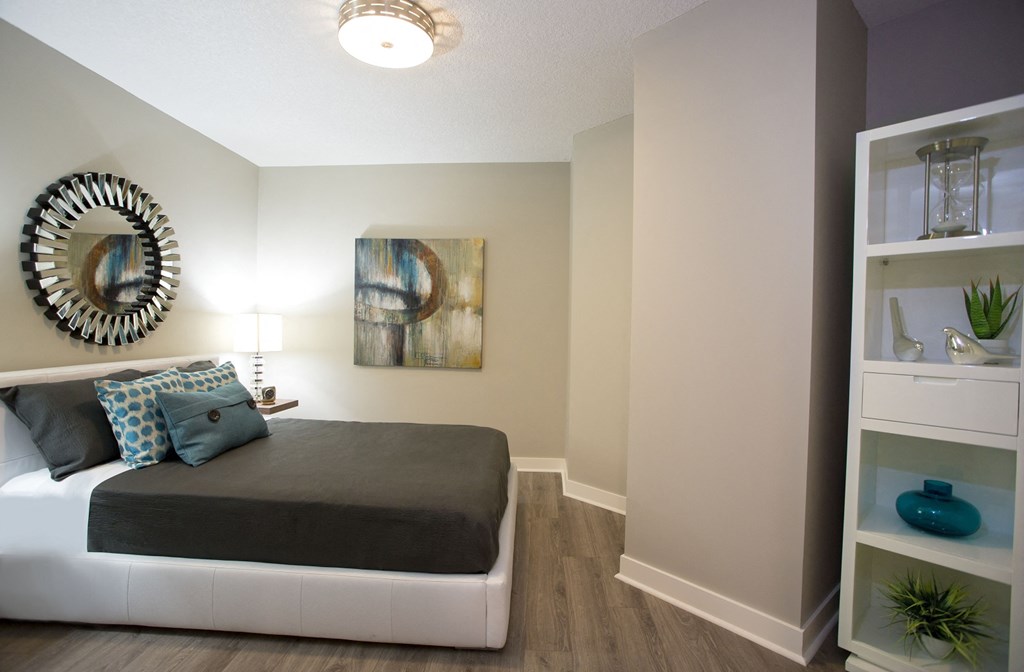 a bedroom with a bed and a shelf with a mirror