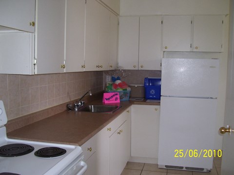 a kitchen with white cabinets and a sink and a refrigerator