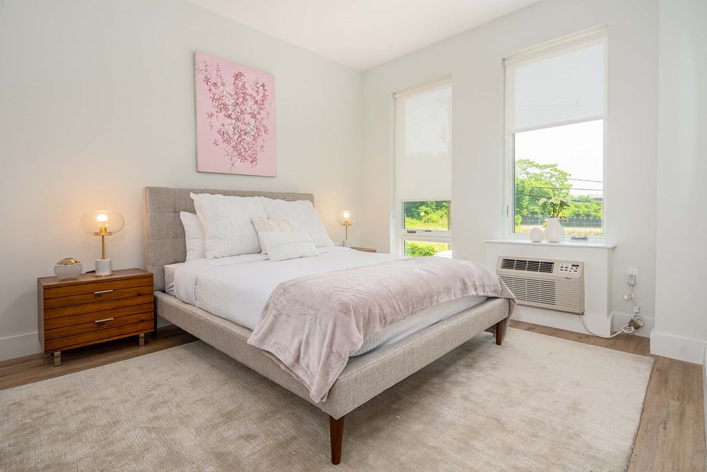 a bedroom with a bed and two windows