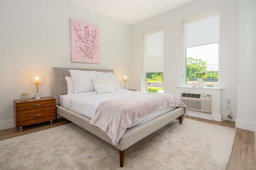 a bedroom with a bed and two windows