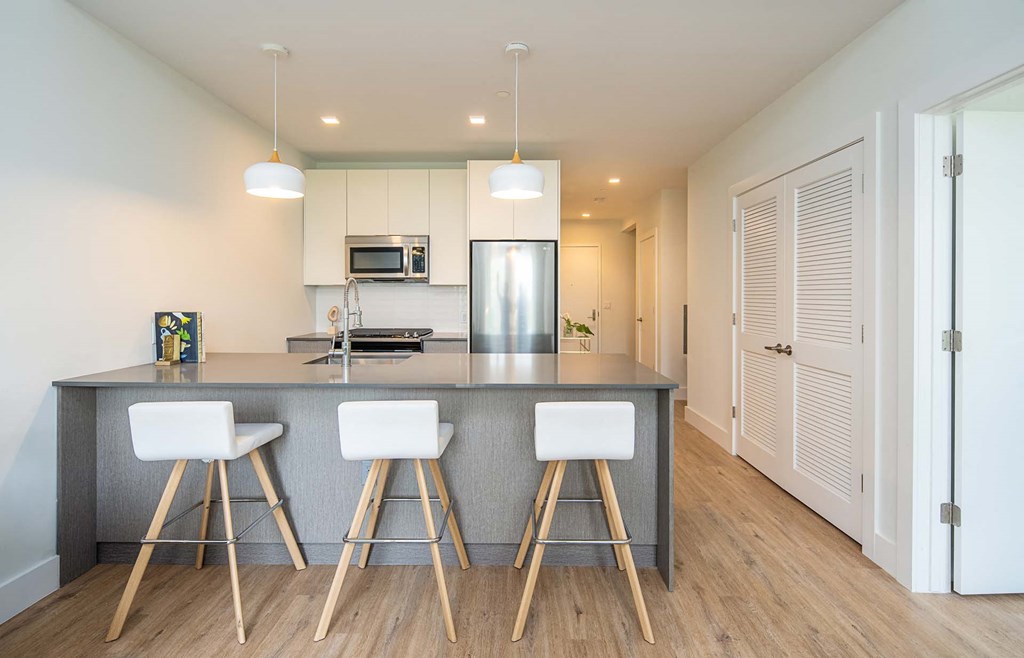 a kitchen with an island and three bar stools