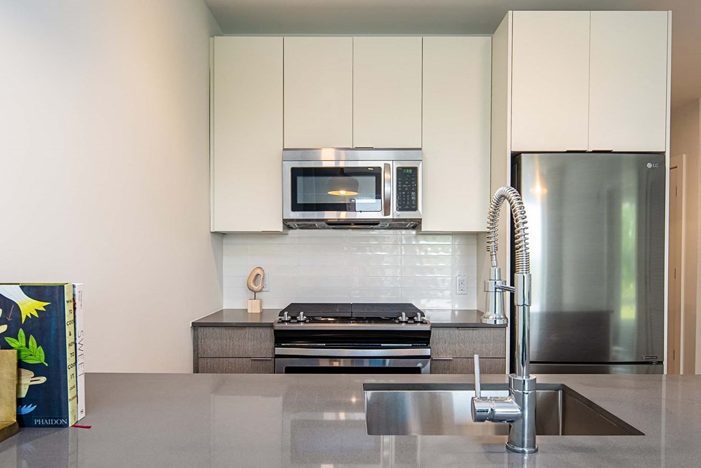 a modern kitchen with white cabinets and stainless steel appliances