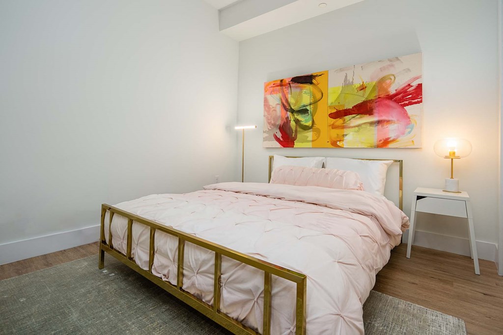 a bedroom with a bed and a painting on the wall