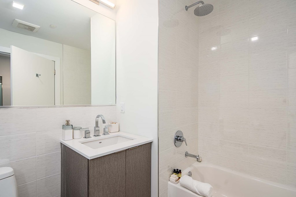 a bathroom with a sink and a tub and a mirror