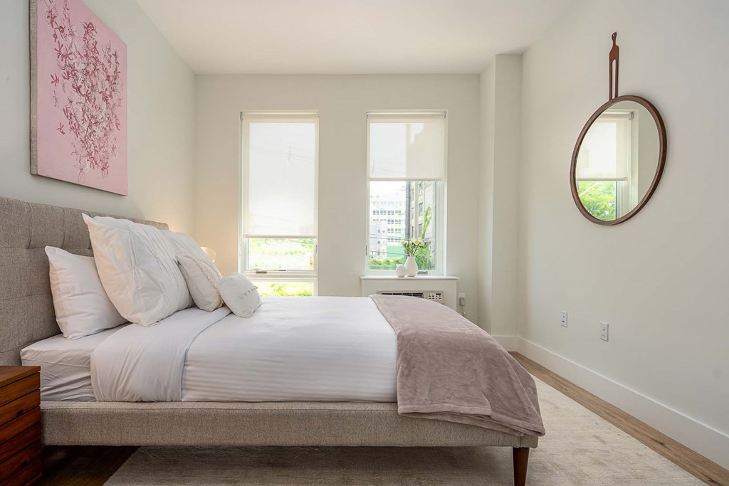 a bedroom with a bed and two windows