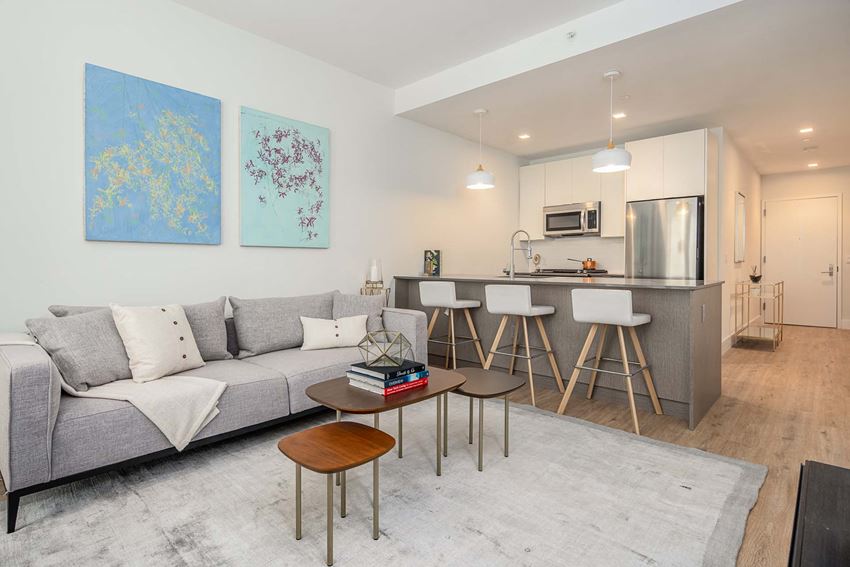 a living room with a couch and a kitchen