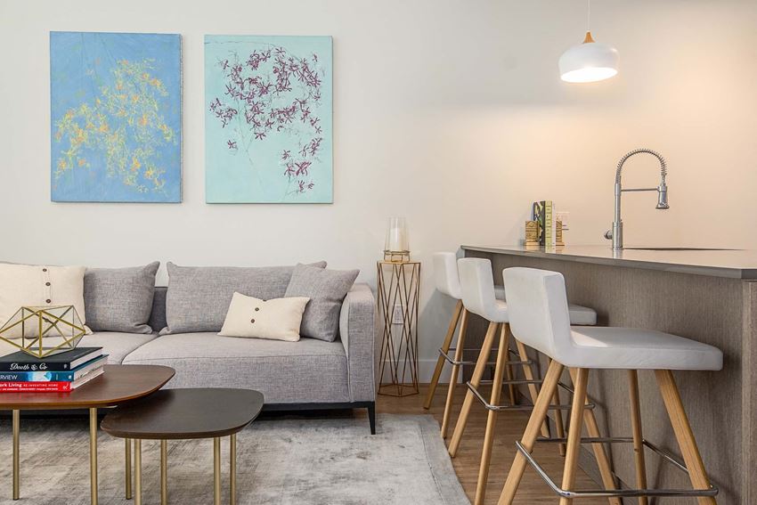 a living room with a couch and a kitchen with a bar