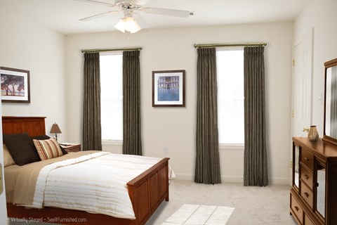 A bedroom with a bed, dresser, and window with curtains.