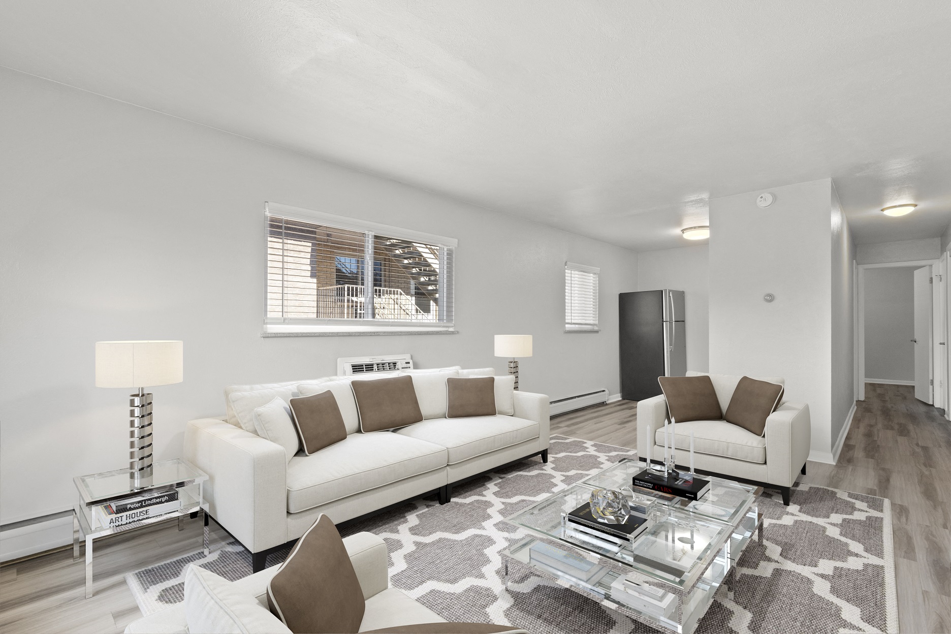 a living room with white couches and a glass coffee table