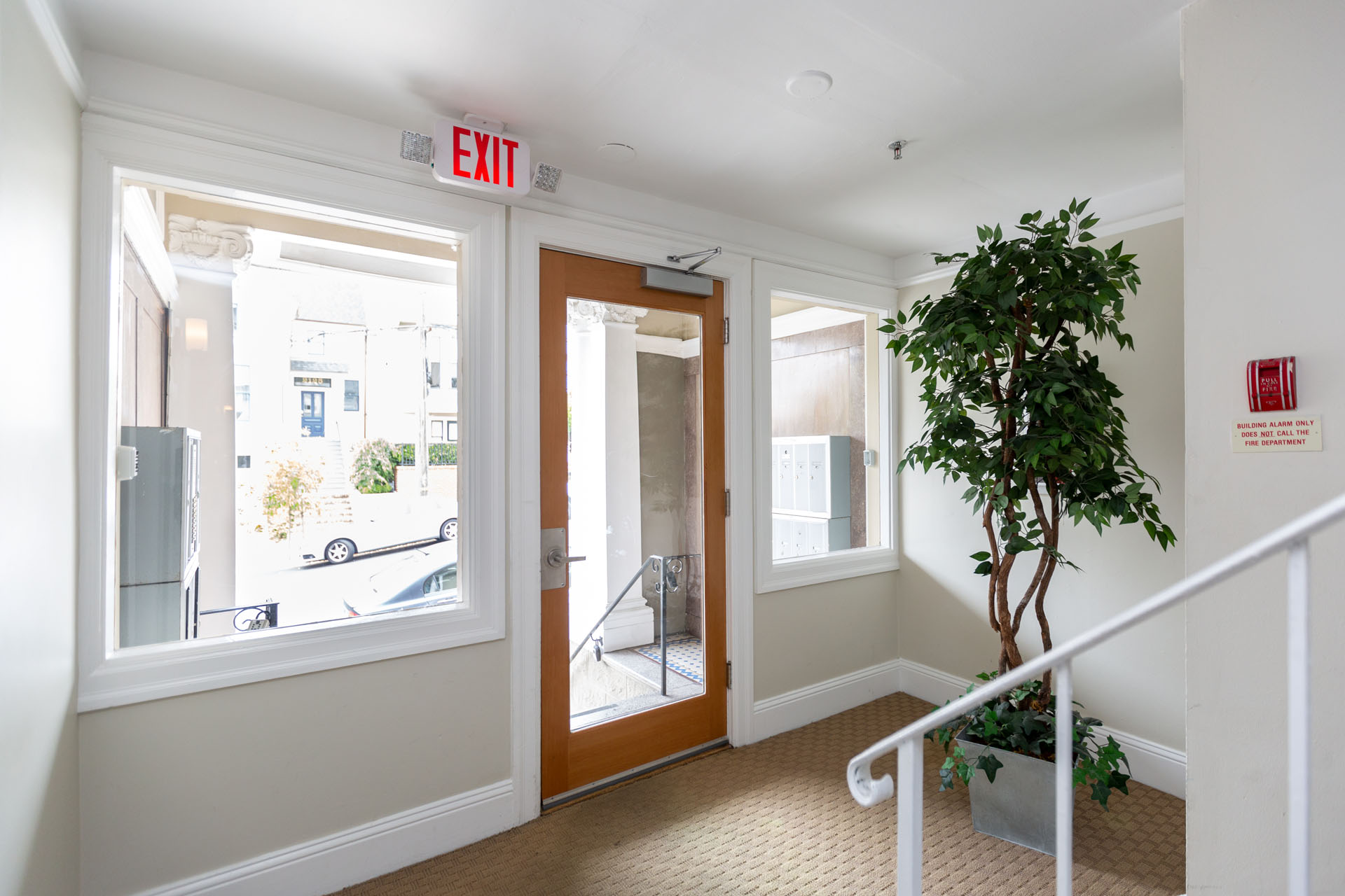 A hallway with a red exit sign above the door.
