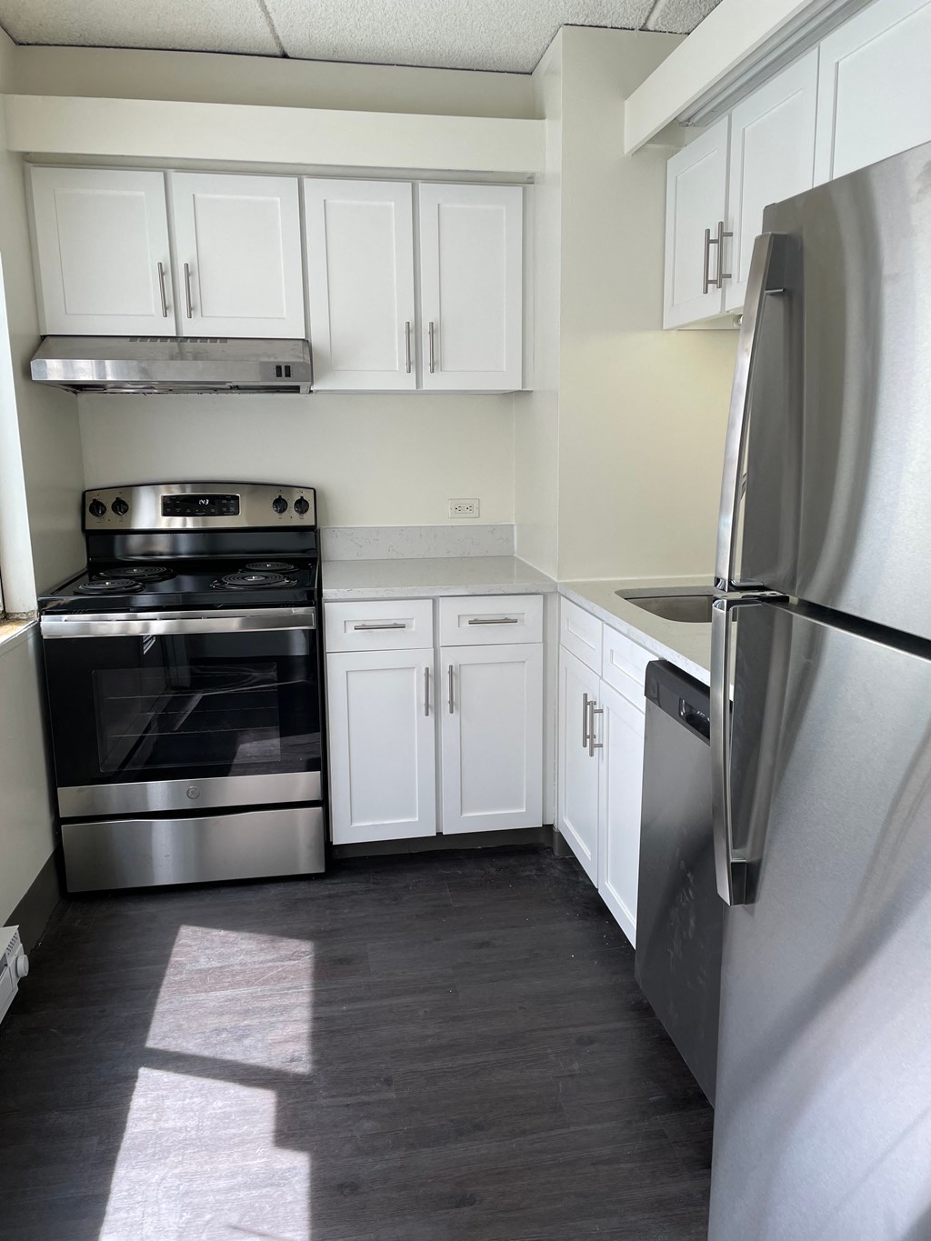 a kitchen with white cabinets and stainless steel appliances