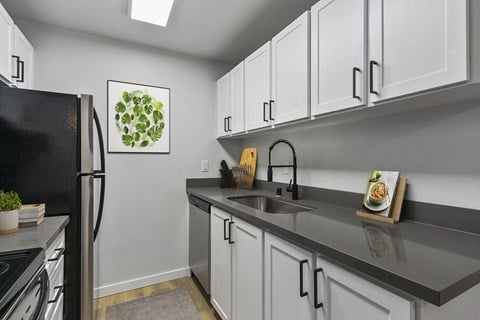 a kitchen with white cabinets and a sink and a refrigerator