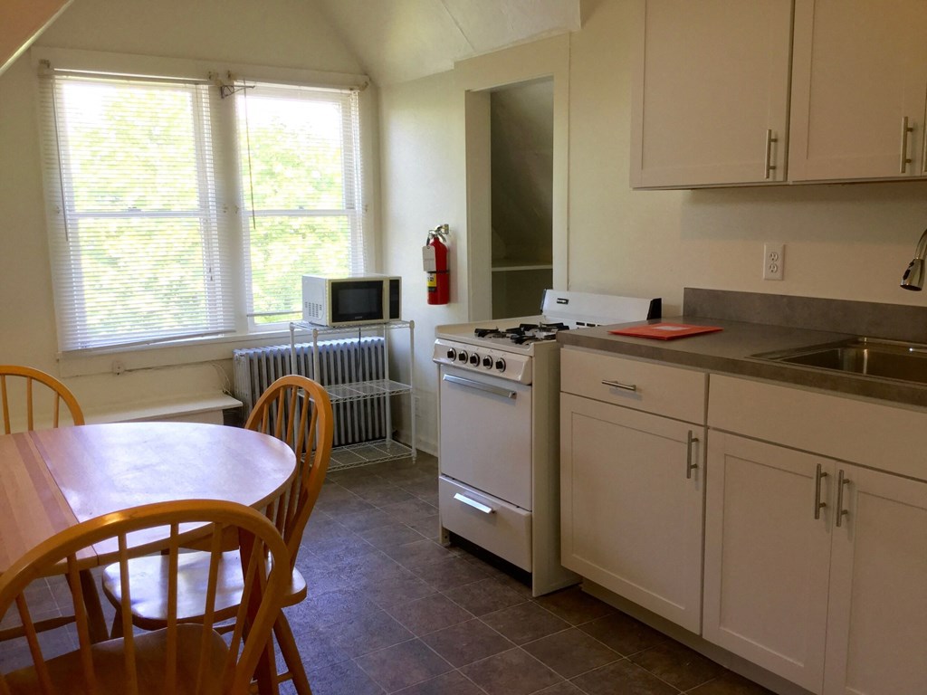 A kitchen with a table and chairs.