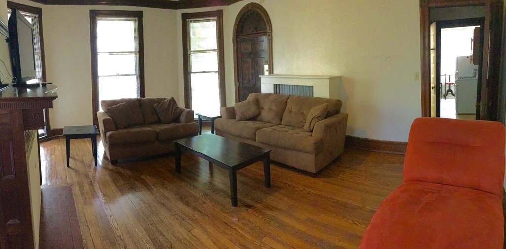 A living room with a brown couch, a brown chair, and a brown sofa.