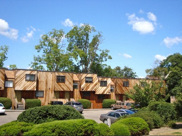 a large wooden building with cars parked in a parking lot