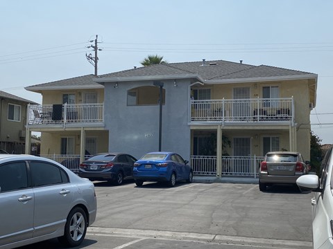 a large apartment complex with cars parked in front of it