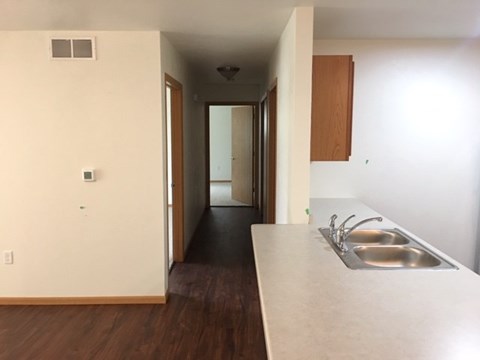 A kitchen with a sink and a hallway.