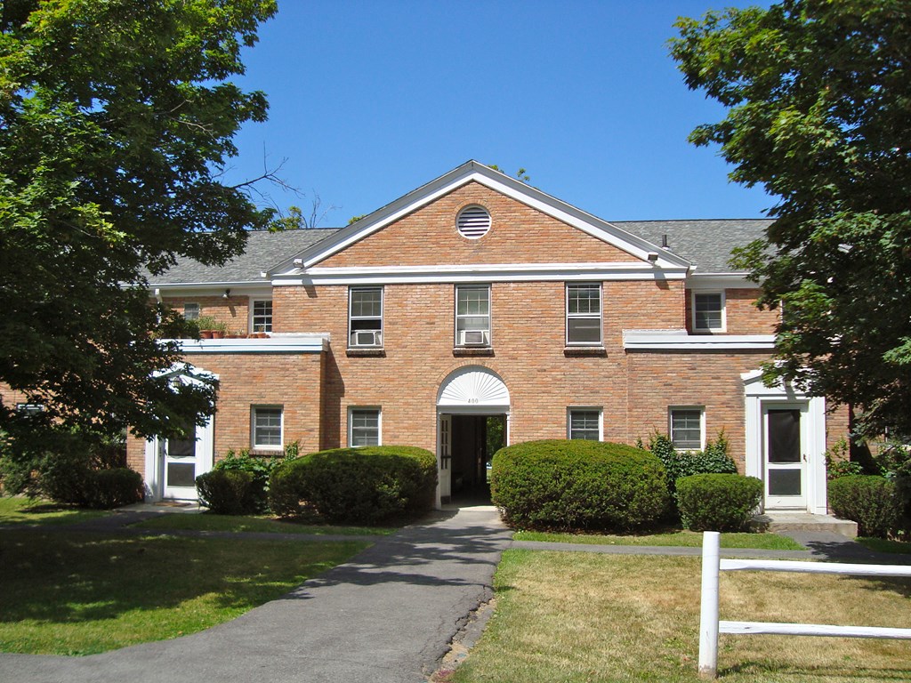 a large brick building with a sidewalk in front of it