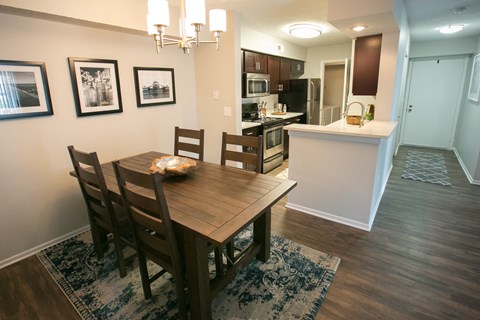 a dining room and kitchen with a wooden table and chairs