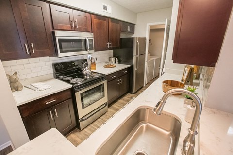 a kitchen with stainless steel appliances and wooden cabinets and a sink